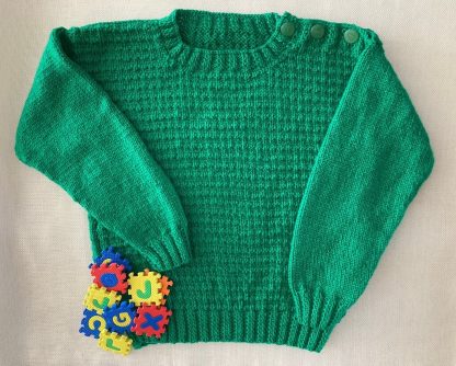 Hand knitted dark green jumper with a distinctive pattern Round neck Buttons on one shoulder