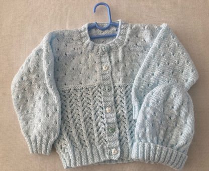 Exquisite lacy cardigan hand knitted in softest baby yarn in pale blue with matching beanie and with 6 whimsical alternating blue and white little duck buttons