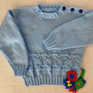 Hand knitted jumper in blue yarn crafted in an adorable owl motif Round neck 3 Buttons on one shoulder Long sleeves Ribbing around neckline, cuffs and hem