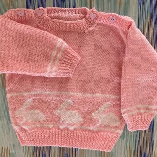 Hand knitted jumper in pink with a row of rabbits featured front and back Beautiful pink heart buttons on both shoulders