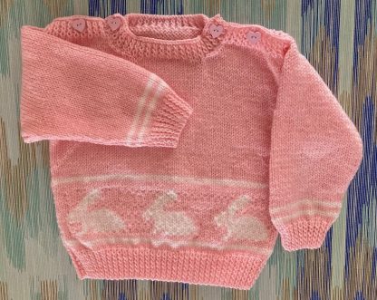 Hand knitted jumper in pink with a row of rabbits featured front and back Beautiful pink heart buttons on both shoulders