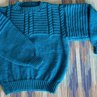 Hand knitted blue jumper in a stunning pattern Round neck Long sleeves Ribbing around neckline, cuffs and hem 100% Acrylic yarn Completed garment measurements Chest all around: 76cm Length, shoulder to hem ribbing: 39cm Sleeve seam length: 35cm For ages 5-6 years